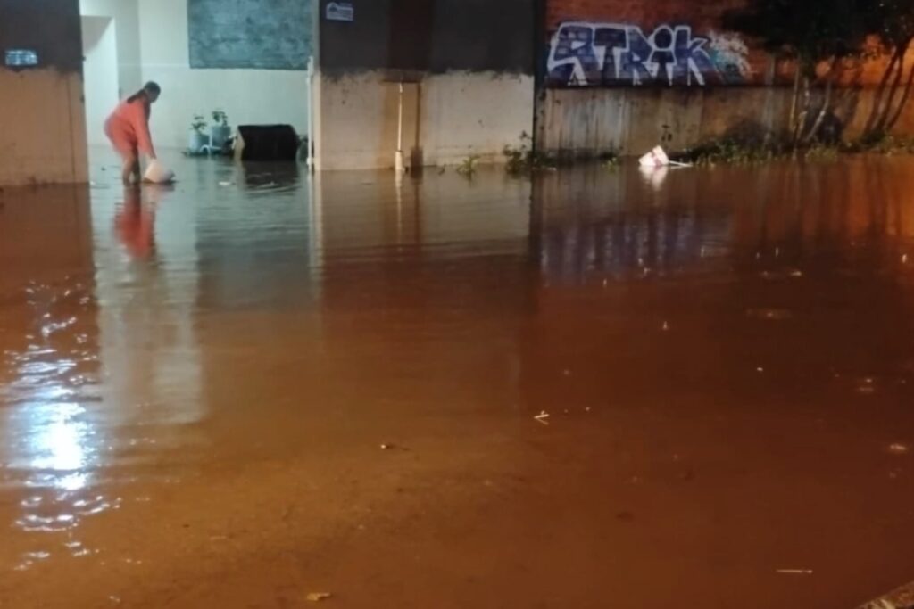 Rua alagada em município do Paraná após dias seguidos de chuva forte.